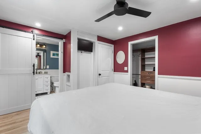 a bedroom with a large bed and a large mirror