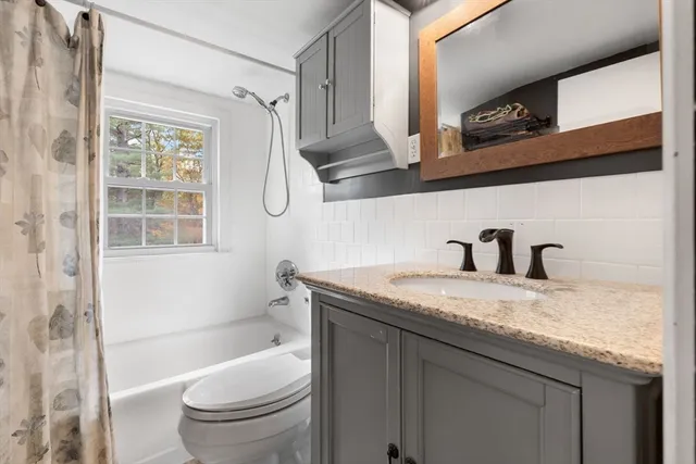 a bathroom with a granite countertop sink toilet and shower