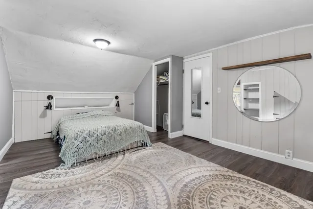 a bedroom with a large bed and wooden floor