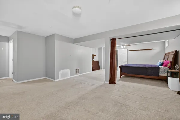 a view of an empty room with closet and a window