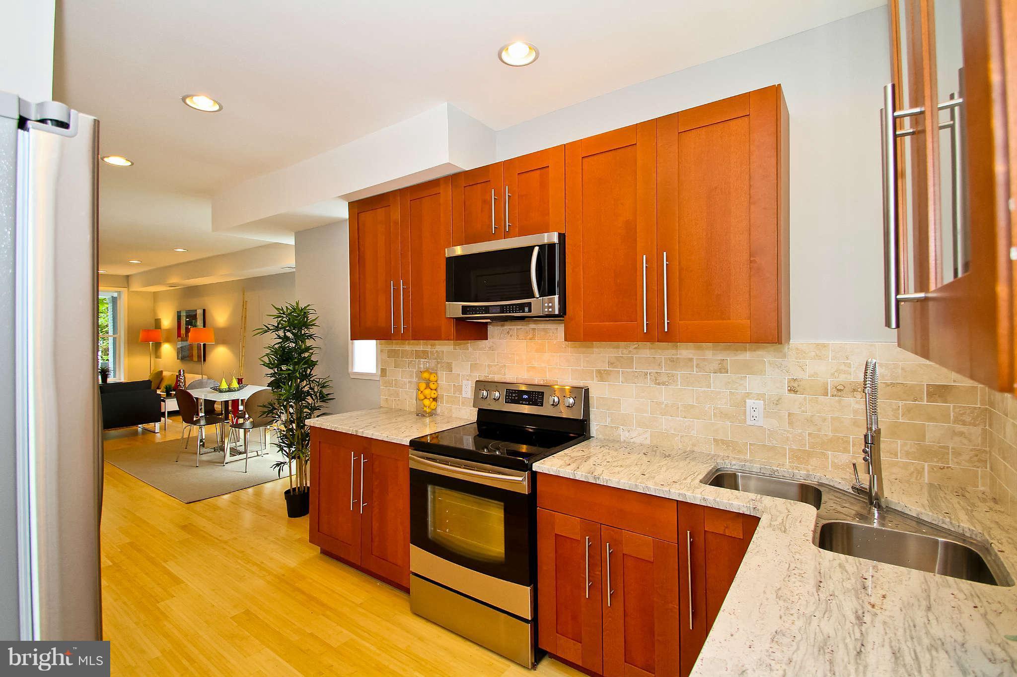 604 Columbia Road Northwest Washington, DC 20001 - Photo 5 of 25 a kitchen with stainless steel appliances granite countertop a stove a sink and a microwave