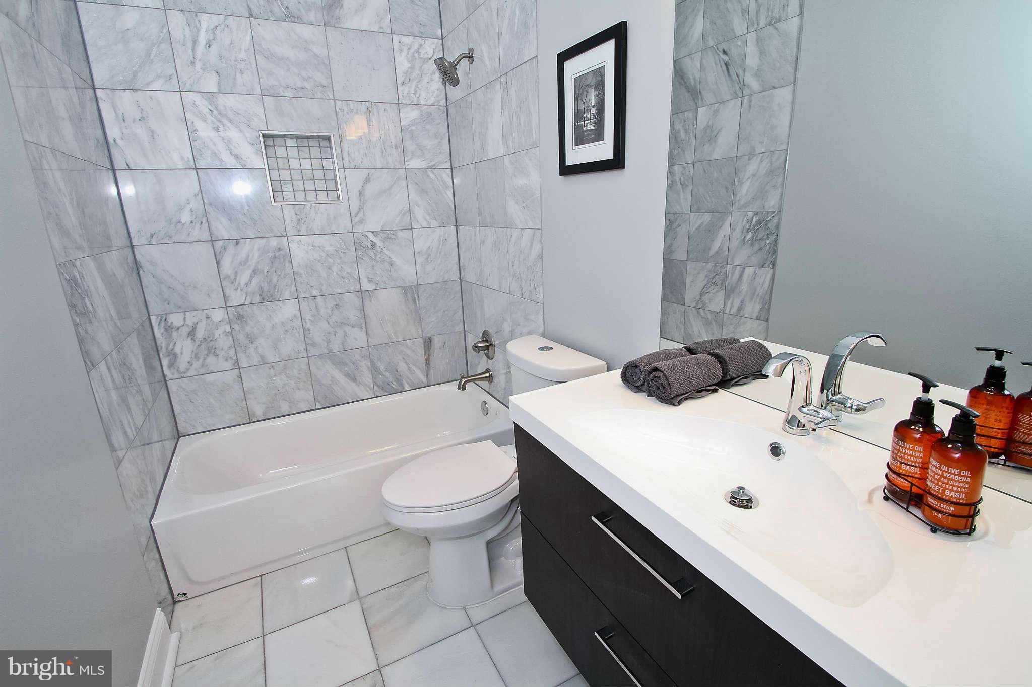 604 Columbia Road Northwest Washington, DC 20001 - Photo 9 of 25 a bathroom with a sink a toilet and shower