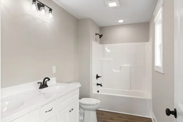a bathroom with a bathtub shower sink vanity and toilet