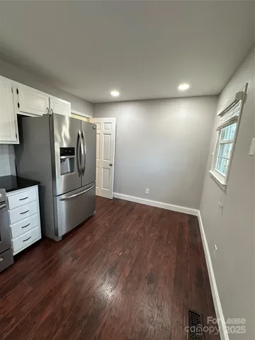 a kitchen with stainless steel appliances a refrigerator and wooden floor