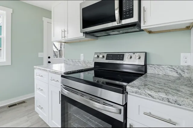 a kitchen with stainless steel appliances granite countertop a stove and a microwave