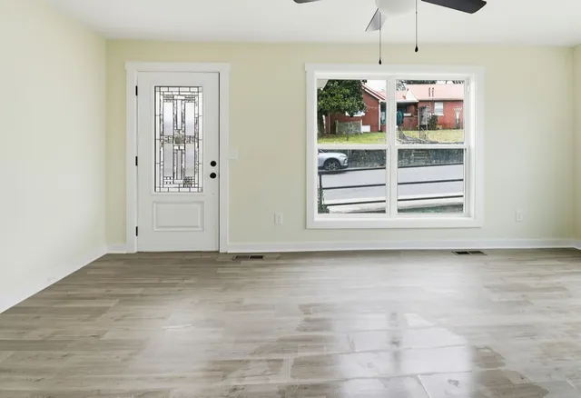 a view of an empty room with a cabinet and window
