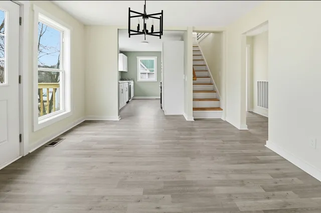 a view of a hallway with wooden floor and entryway