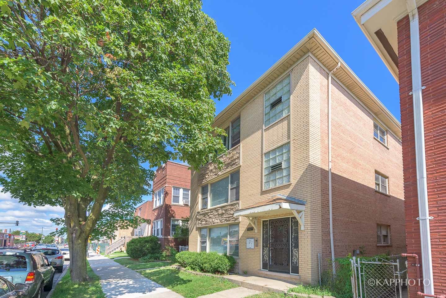 5942 West Addison Street, Unit 1 Chicago, IL 60634 - Photo 24 of 24 a view of a brick house with a large windows and a tree