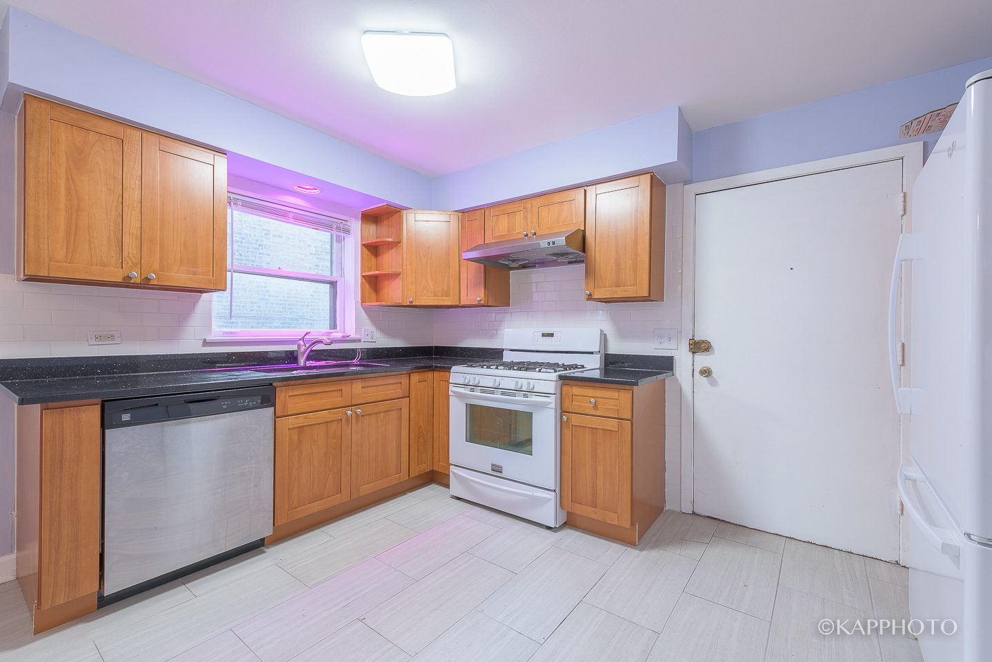5942 West Addison Street, Unit 1 Chicago, IL 60634 - Photo 9 of 24 a kitchen with granite countertop a sink cabinets and stainless steel appliances