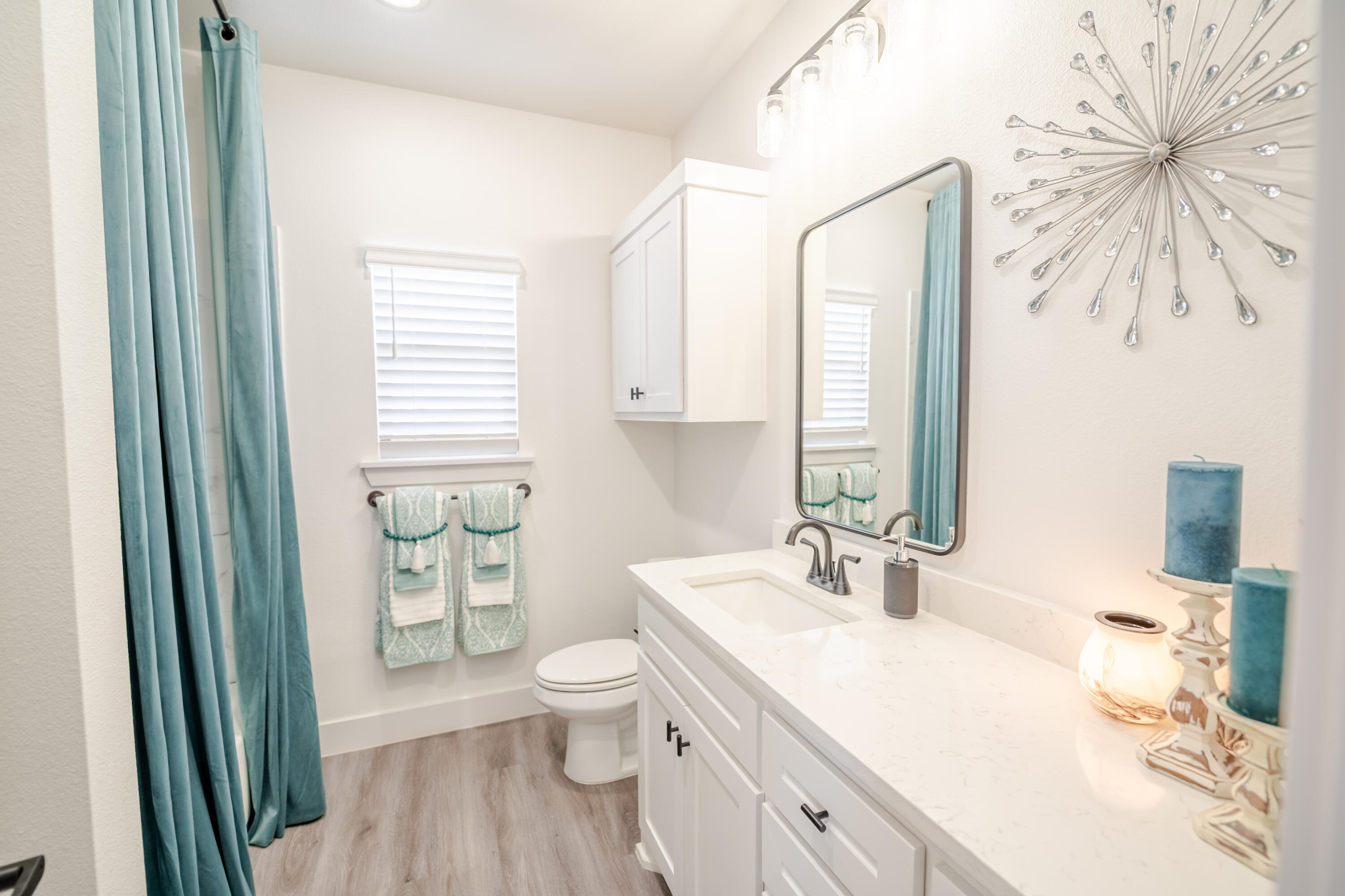 7604 58th Street Lubbock, TX 79407 - Photo 30 of 38 a bathroom with a sink a toilet and a mirror