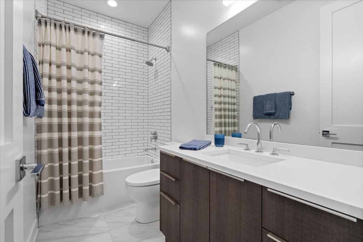 2005 West Huron Street, Unit 1 Chicago, IL 60612 - Photo 23 of 30 a bathroom with a sink a toilet and shower curtain