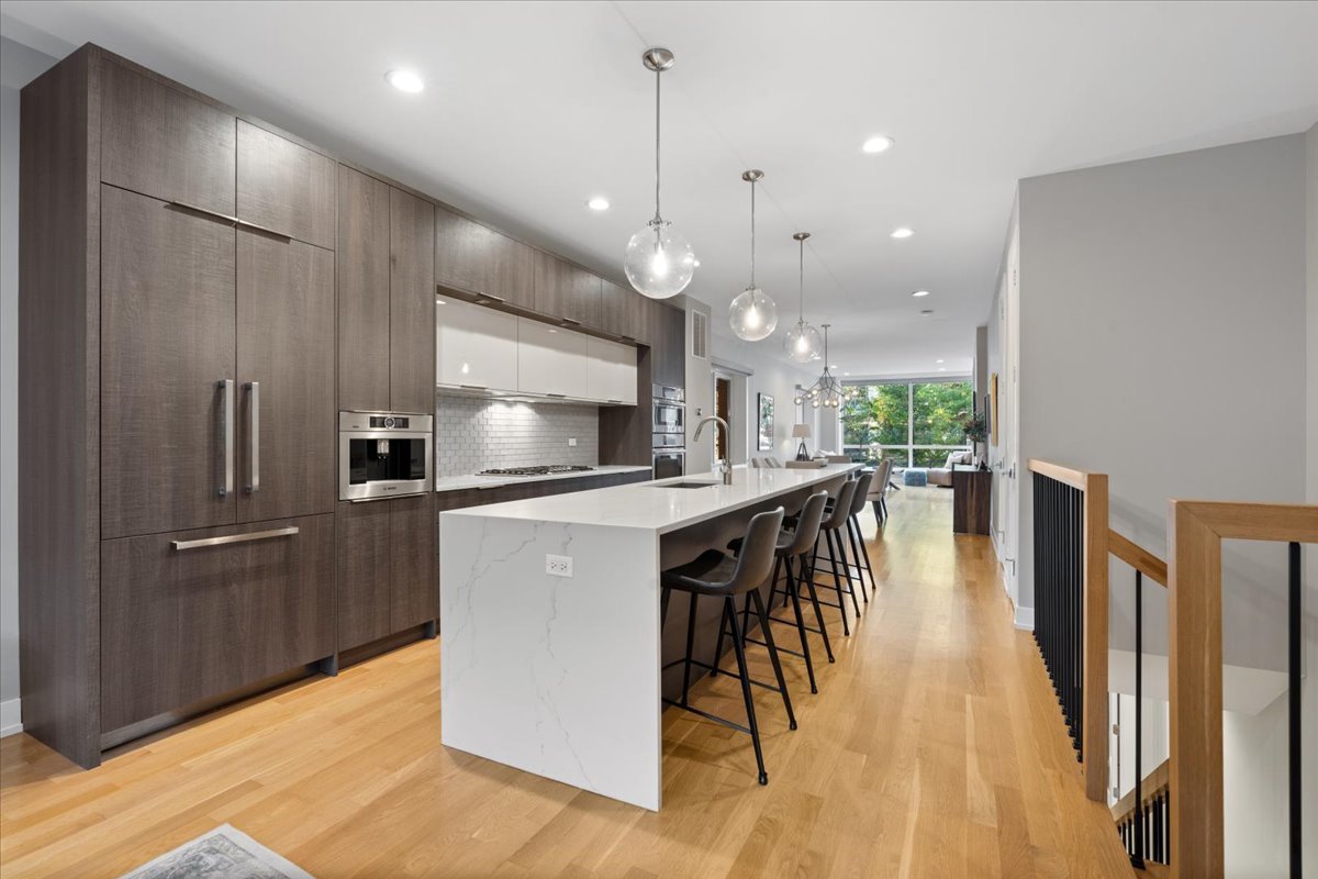 2005 West Huron Street, Unit 1 Chicago, IL 60612 - Photo 9 of 30 a kitchen with stainless steel appliances kitchen island granite countertop a refrigerator a stove a sink a microwave oven with a dining table and chairs