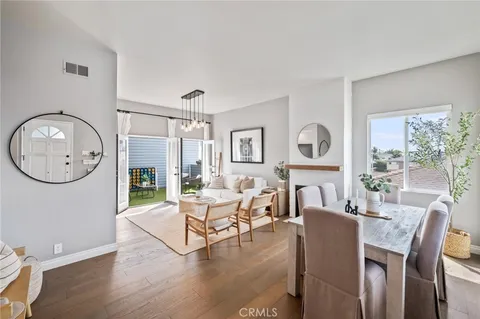 a living room with furniture a large window and wooden floor