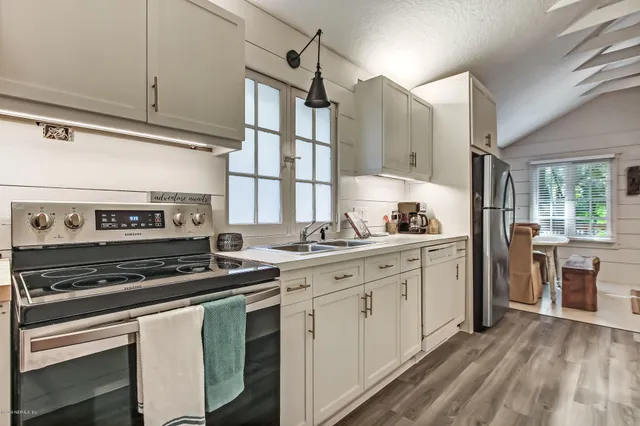 a kitchen with white cabinets and refrigerator