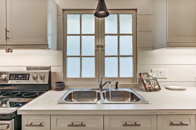 a kitchen with stainless steel appliances a stove and white cabinets