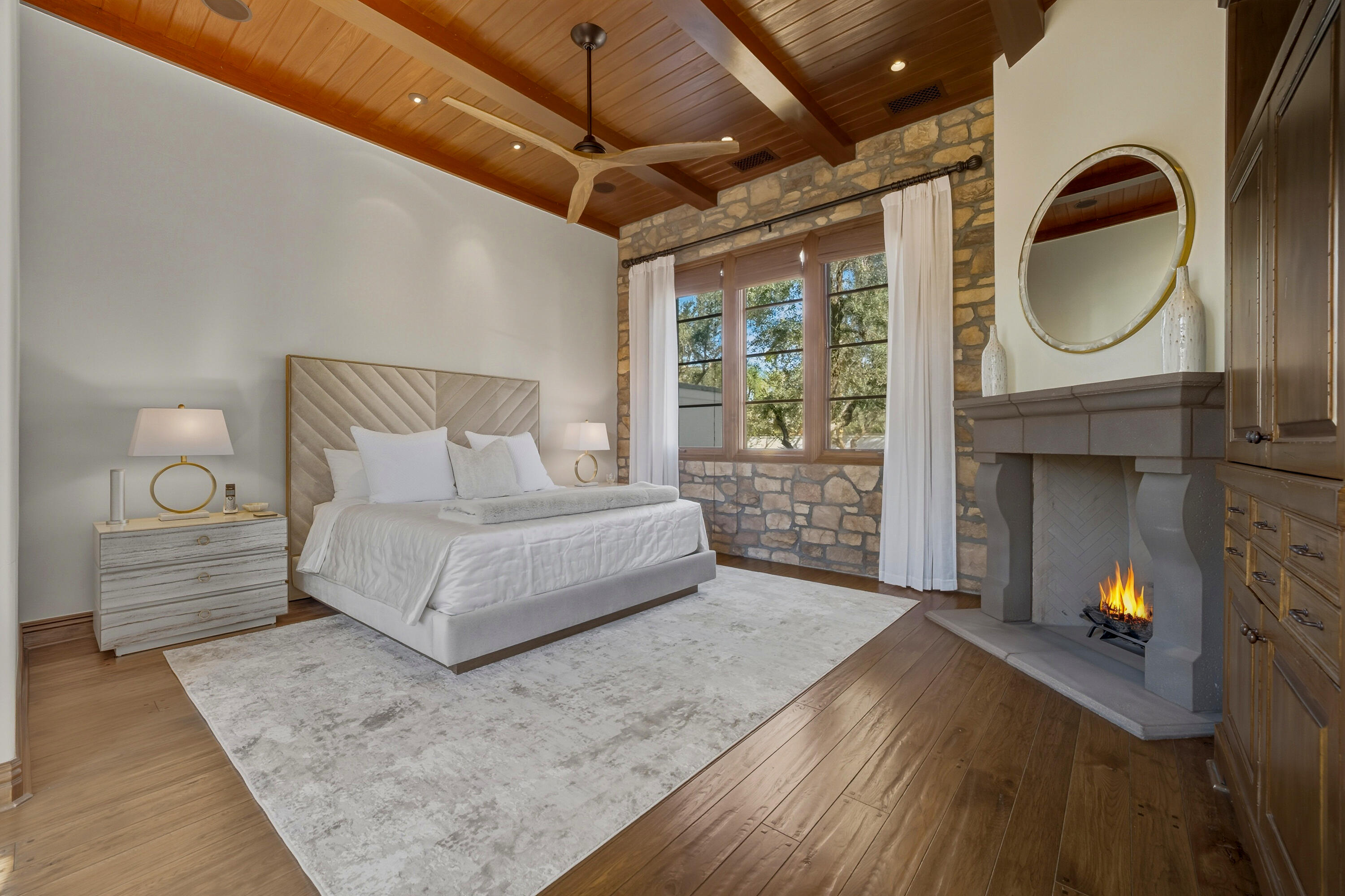 4 Via L' Antico Rancho Mirage, CA 92270 - Photo 26 of 75 a spacious bedroom with a bed a fireplace and a chandelier