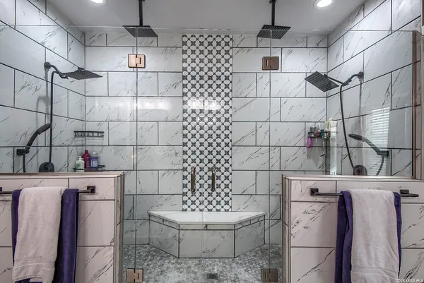 a spacious bathroom with a double vanity sink a toilet a mirror and shower