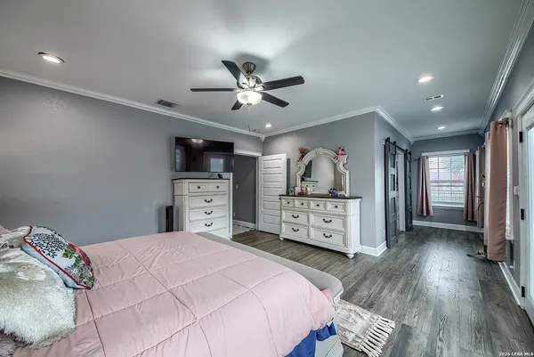 a bedroom with a bed and a flat tv screen on dresser