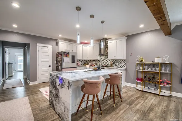 a kitchen with stainless steel appliances a dining table chairs stove and cabinets