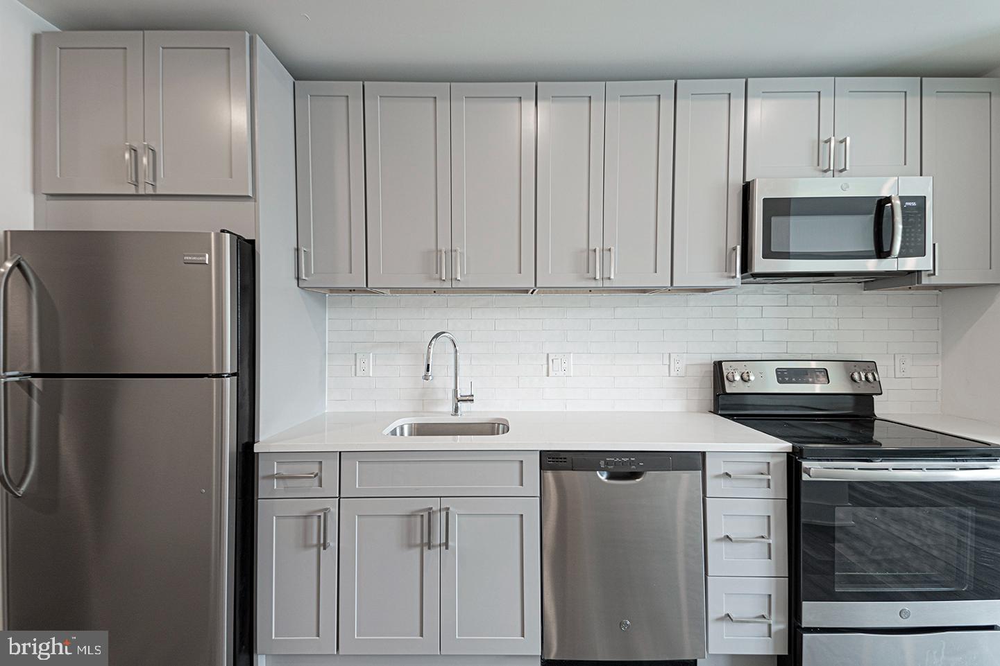 1245 Ridge Avenue, Unit 103 Philadelphia, PA 19123 - Photo 12 of 18 a kitchen with stainless steel appliances white cabinets and a refrigerator