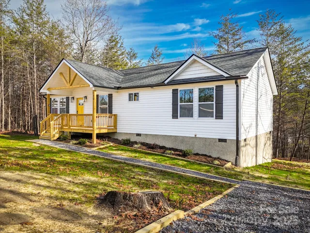 a view of a house with a big yard and large trees
