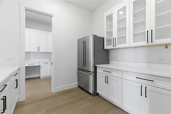 a kitchen with stainless steel appliances white cabinets and a refrigerator