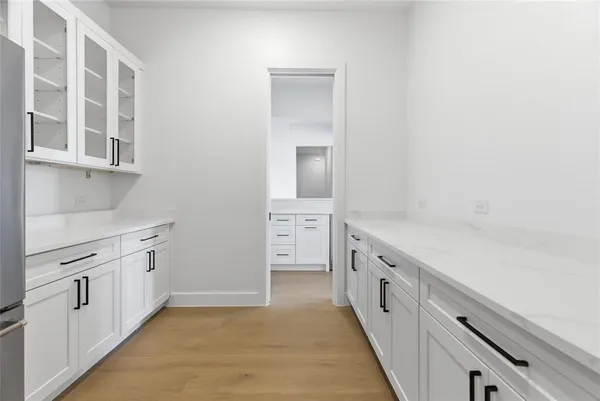 a large white kitchen with granite countertop a sink