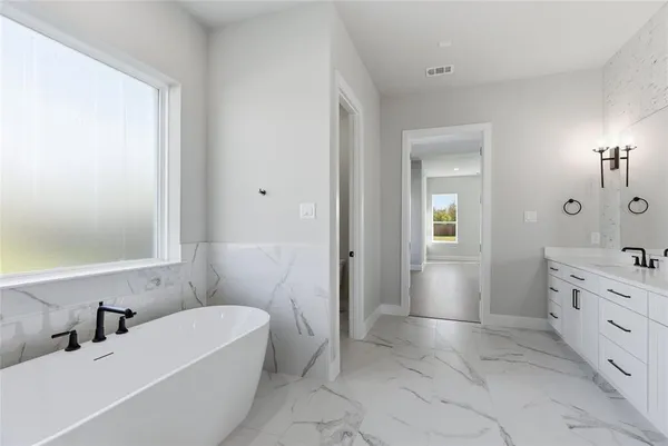 a bathroom with a tub sink and mirror