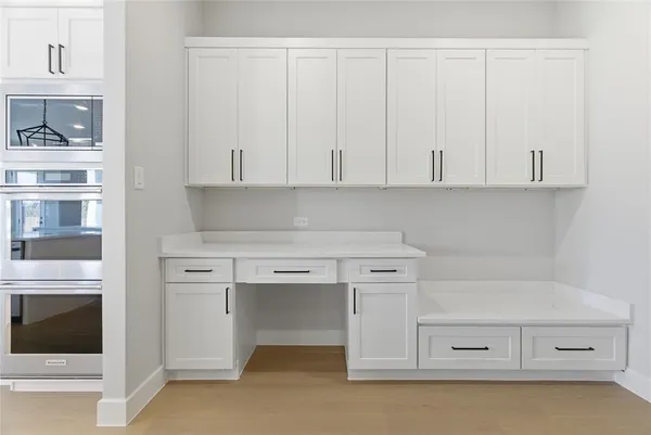 a kitchen with white cabinets and a stove