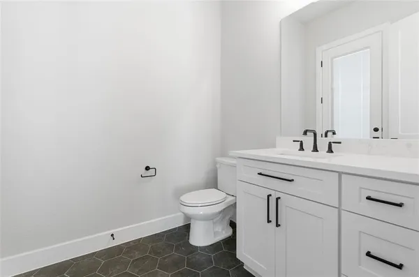 a bathroom with a sink a toilet and a mirror