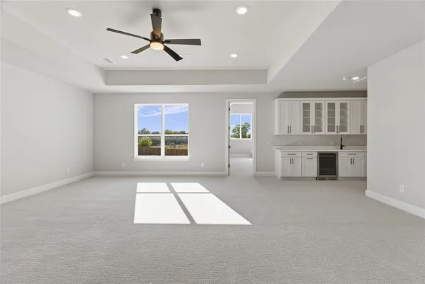 a view of an empty room with a window and a kitchen