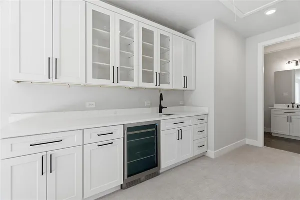 a kitchen with white cabinets and sink