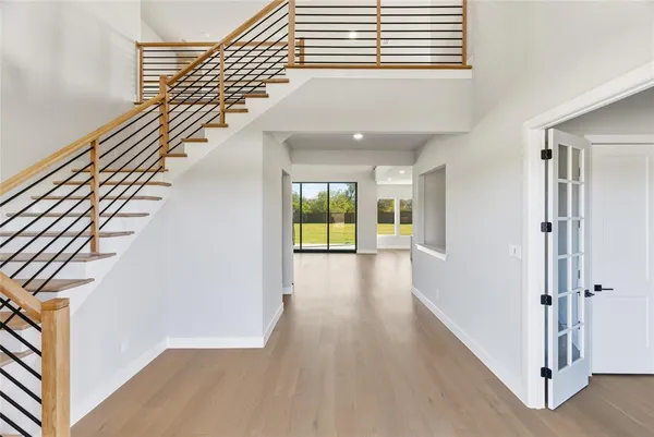 a view of a hallway with wooden floor and staircase