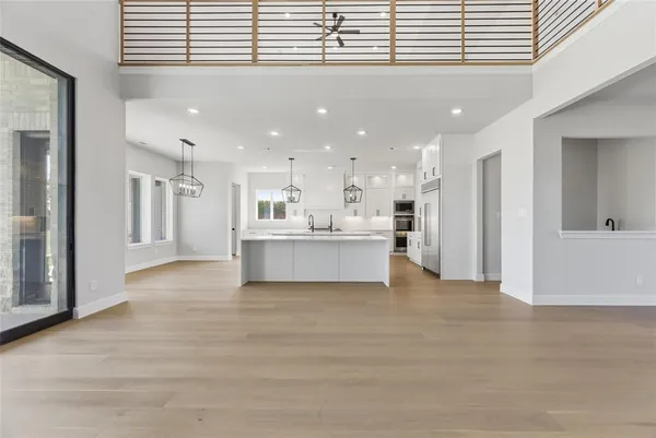 a view of a kitchen with kitchen island a refrigerator a sink dishwasher with a dining table and chairs