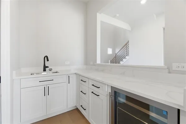 a kitchen with white cabinets a sink and dishwasher