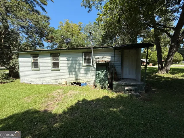 a backyard of a house with yard and outdoor seating