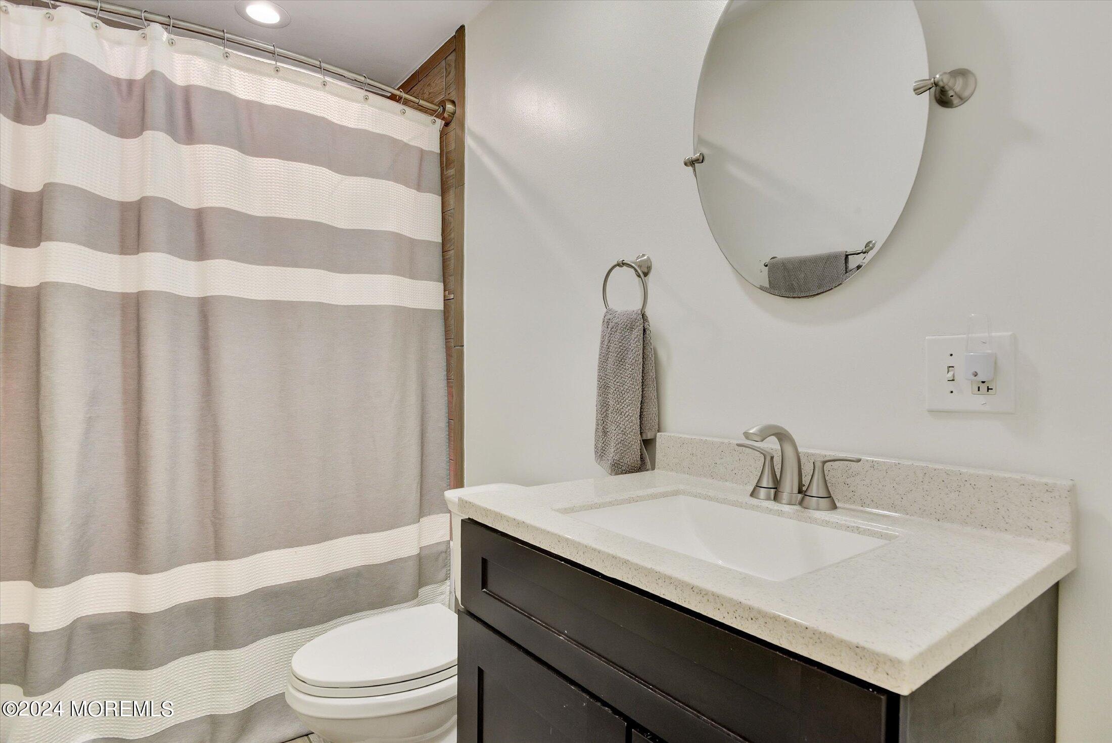 155 Tyrpak Road Howell, NJ 07731 - Photo 17 of 35 a bathroom with a sink toilet a mirror and shower curtain