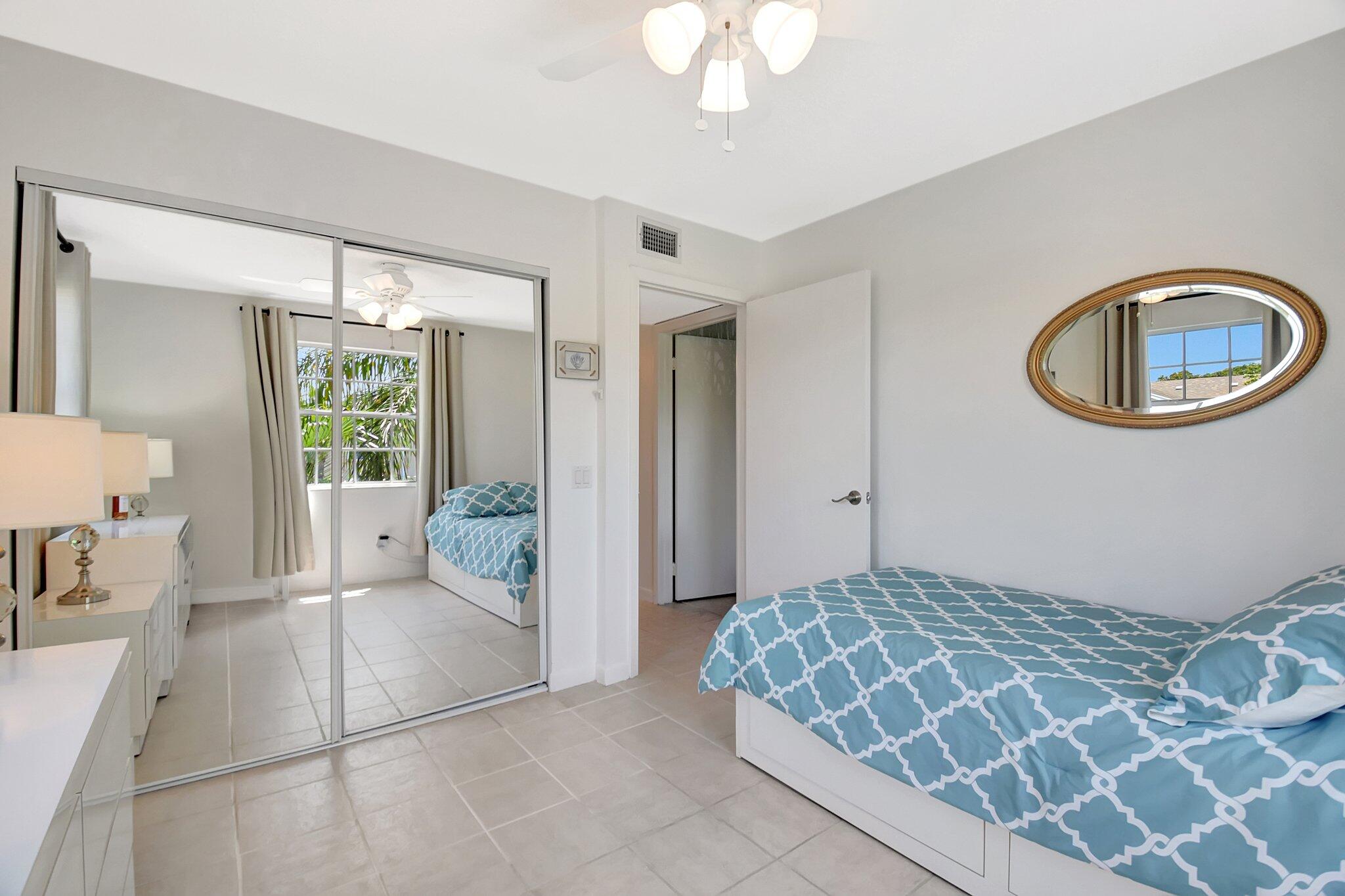 621 Waterside Drive Hypoluxo, FL 33462 - Photo 13 of 27 a bedroom with a large bed and a chandelier