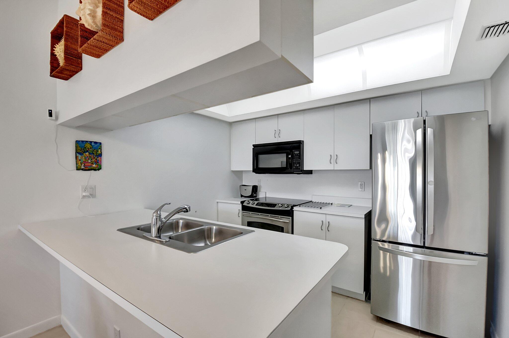 621 Waterside Drive Hypoluxo, FL 33462 - Photo 6 of 27 a kitchen with appliances a sink and cabinets