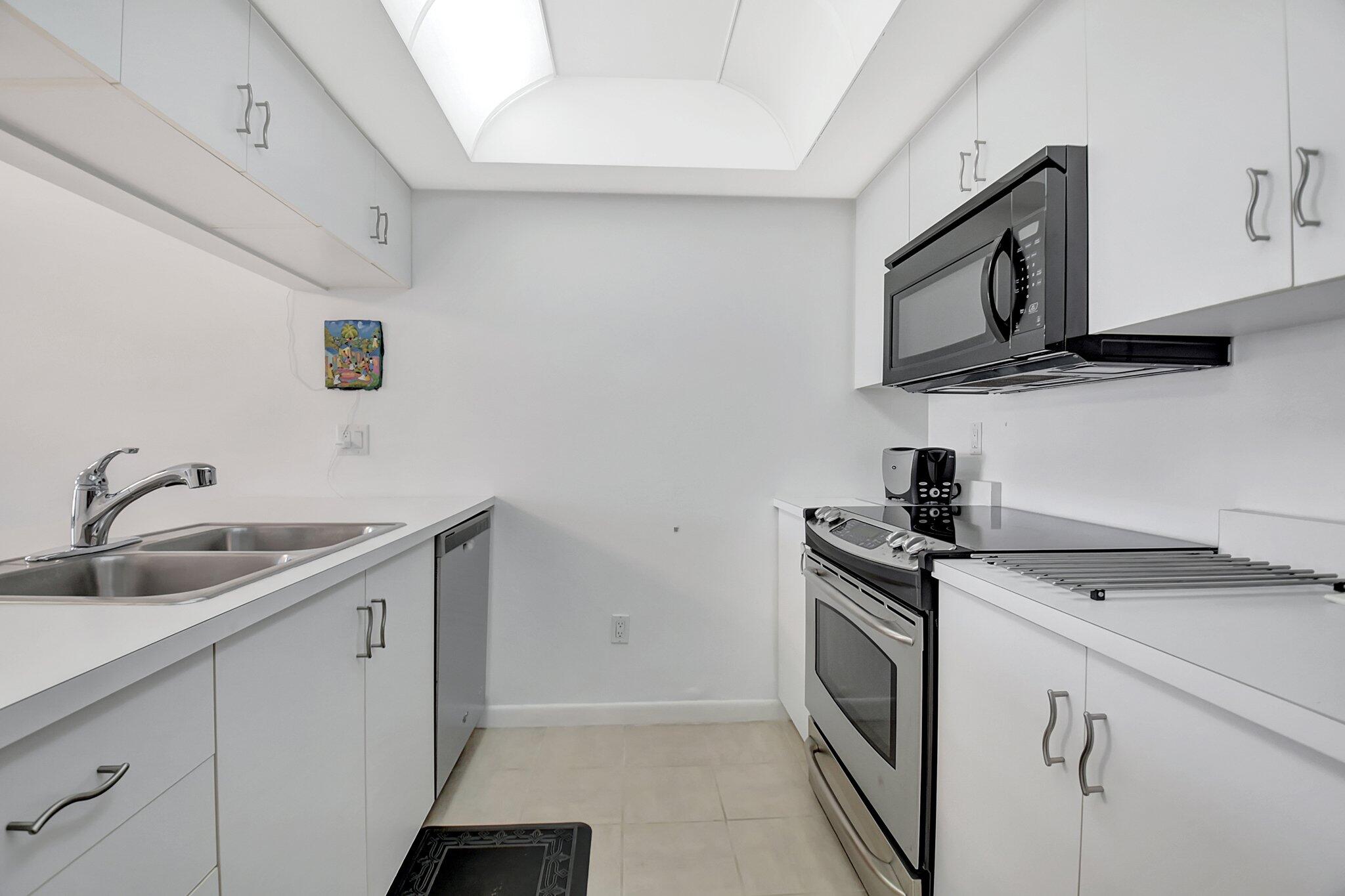 621 Waterside Drive Hypoluxo, FL 33462 - Photo 7 of 27 a kitchen with a sink stove and microwave