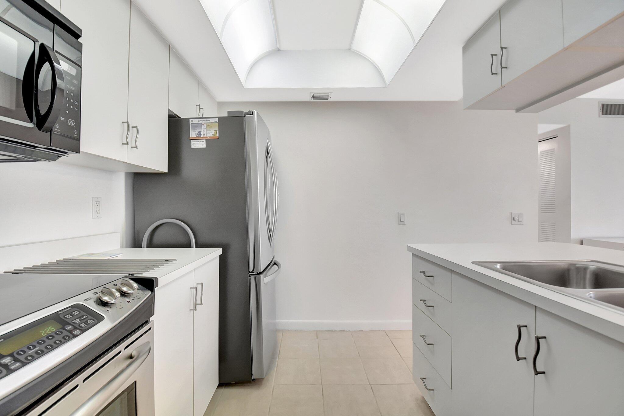 621 Waterside Drive Hypoluxo, FL 33462 - Photo 8 of 27 a view of a kitchen with sink stove and refrigerator