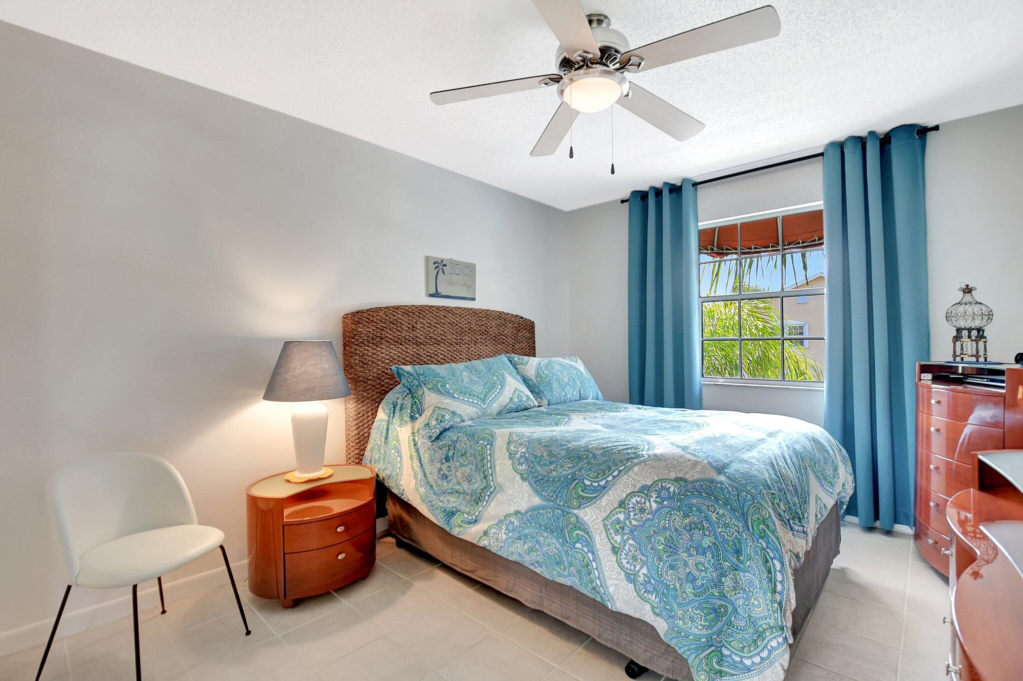621 Waterside Drive Hypoluxo, FL 33462 - Photo 9 of 27 a bedroom with a bed and a chandelier
