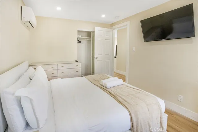 a bedroom with a large bed and a flat screen tv