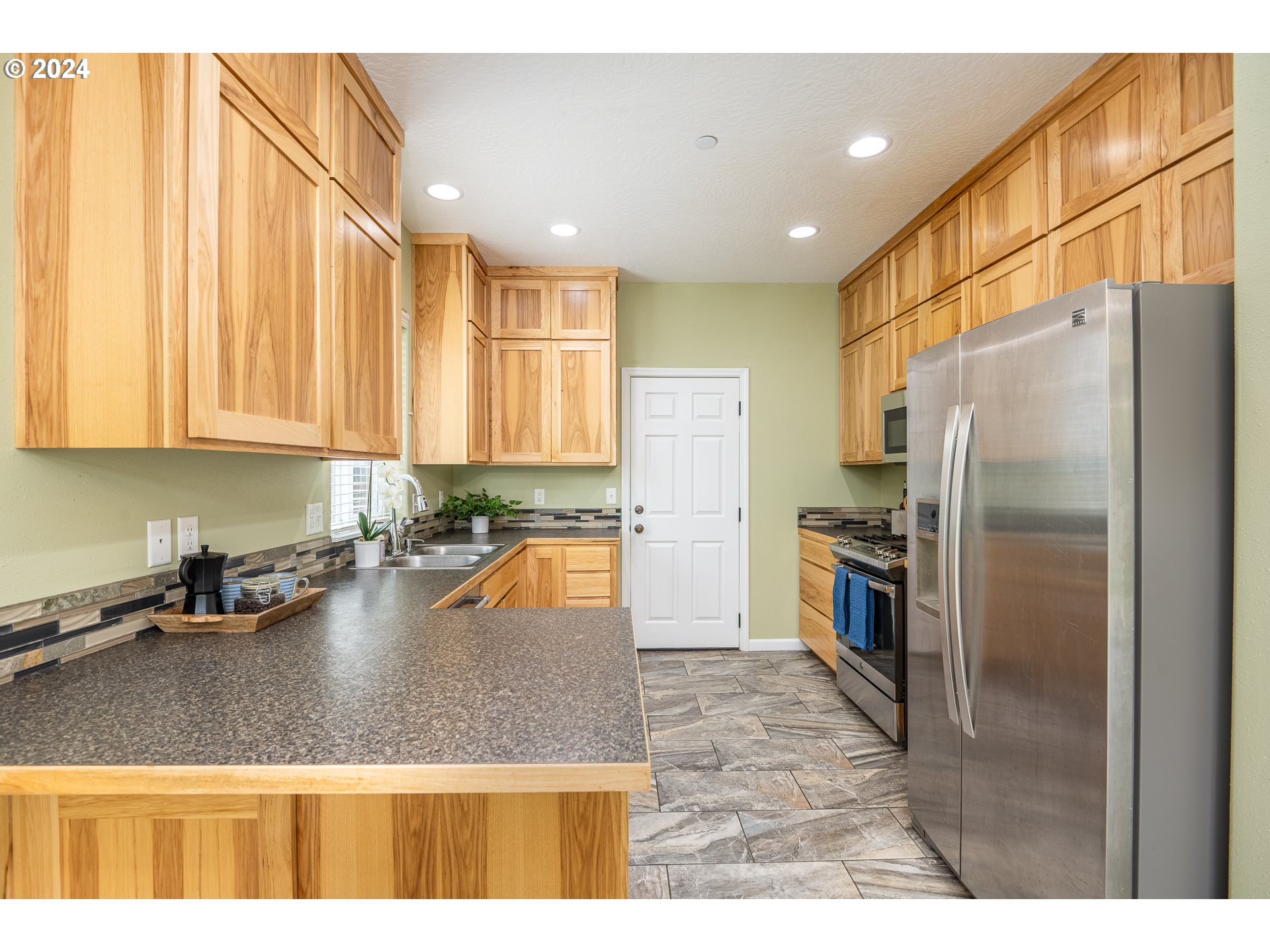 1455 South 58th Street Springfield, OR 97478 - Photo 17 of 39 a kitchen with stainless steel appliances granite countertop a refrigerator a sink a stove and island
