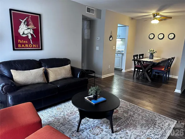 a living room with furniture and a wooden floor