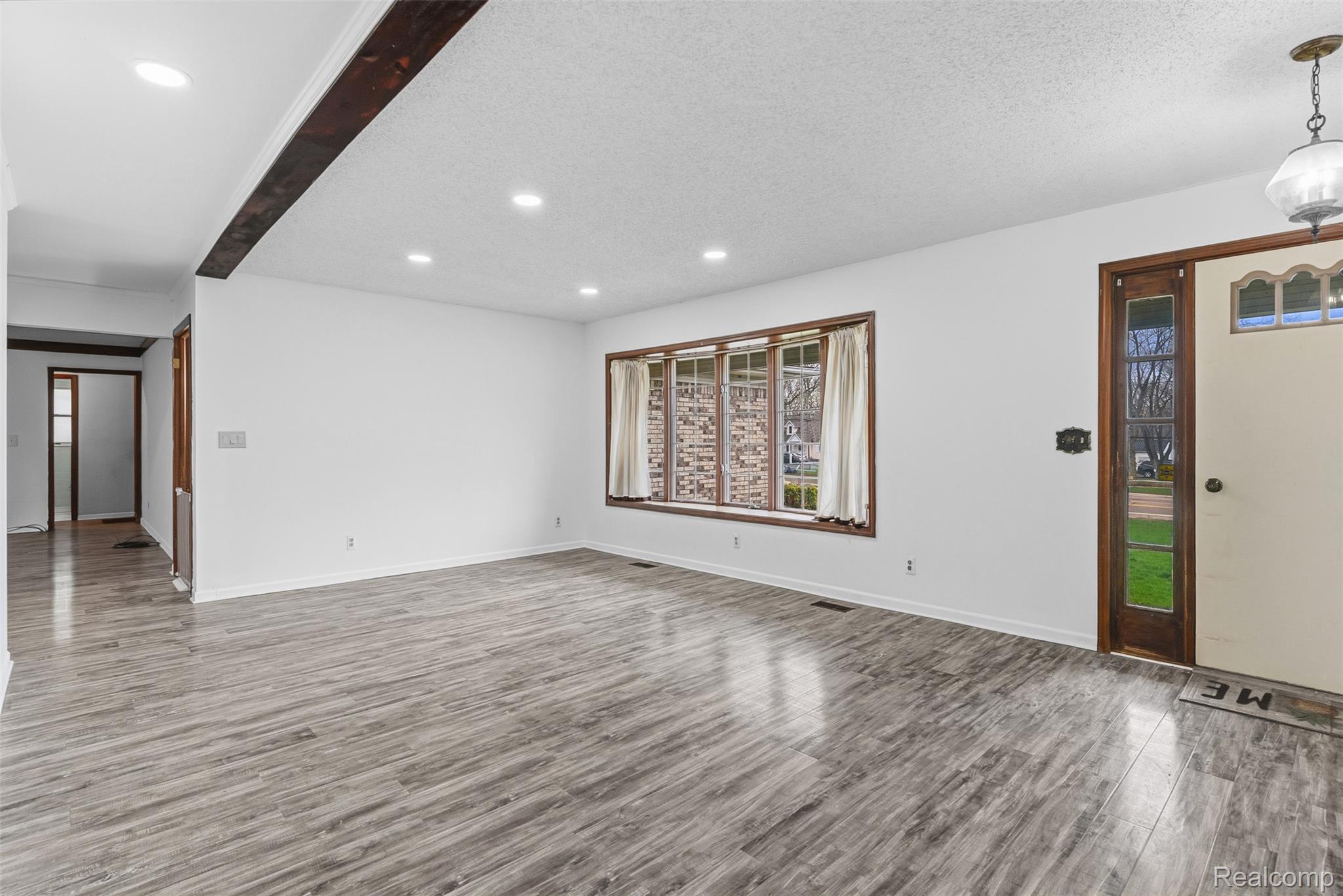 3432 South State Road Davison, MI 48423 - Photo 9 of 58 Unfurnished living room featuring recessed lighting, dark wood-style floors, beam ceiling, and a textured ceiling