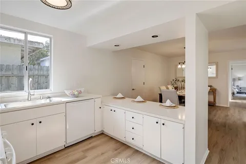 a spacious bathroom with double sink a large mirror a toilet and a window