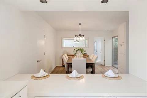 a dining room with wooden floor a chandelier