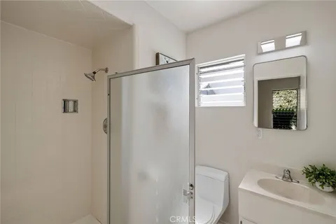 a bathroom with a shower a sink and a mirror