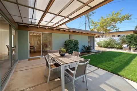 a view of a patio with table and chairs and potted plants